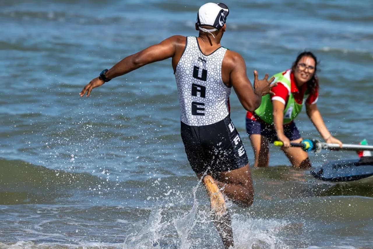 Coastal rowers running up the beach to the finish
