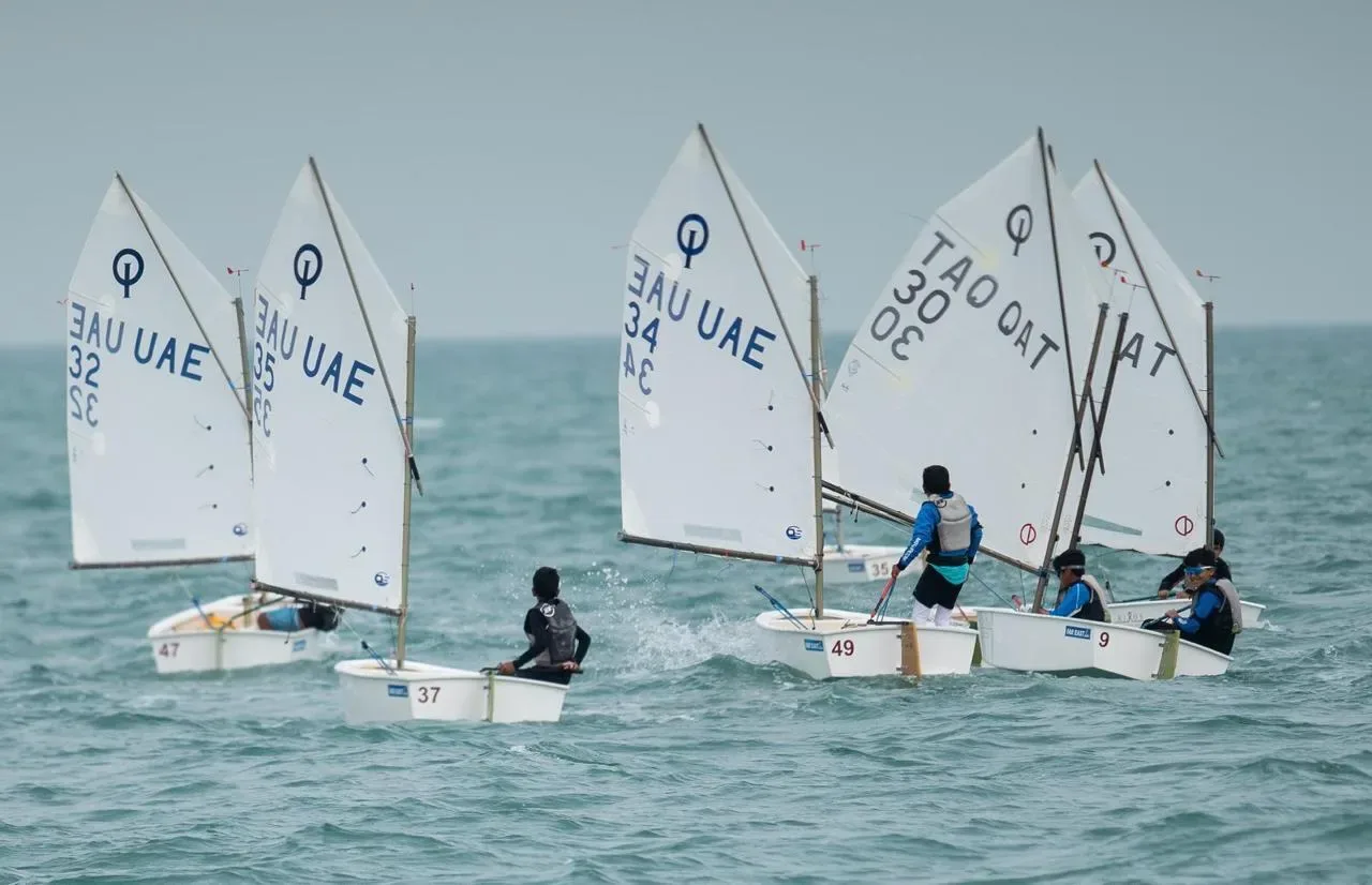 An Optimist fleet racing in light air